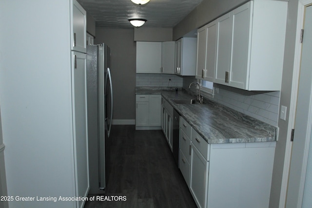 kitchen featuring dark wood-type flooring, sink, stainless steel dishwasher, decorative backsplash, and white cabinets