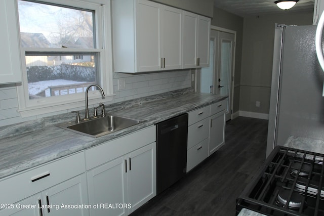 kitchen with sink, stainless steel fridge, black dishwasher, white cabinets, and decorative backsplash