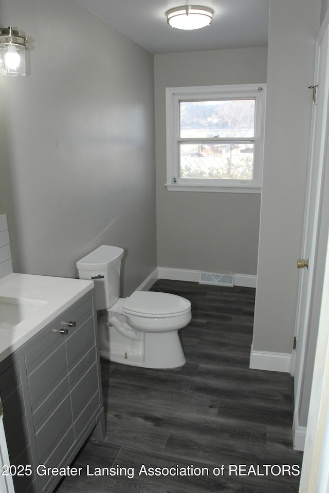 bathroom with vanity, hardwood / wood-style floors, and toilet