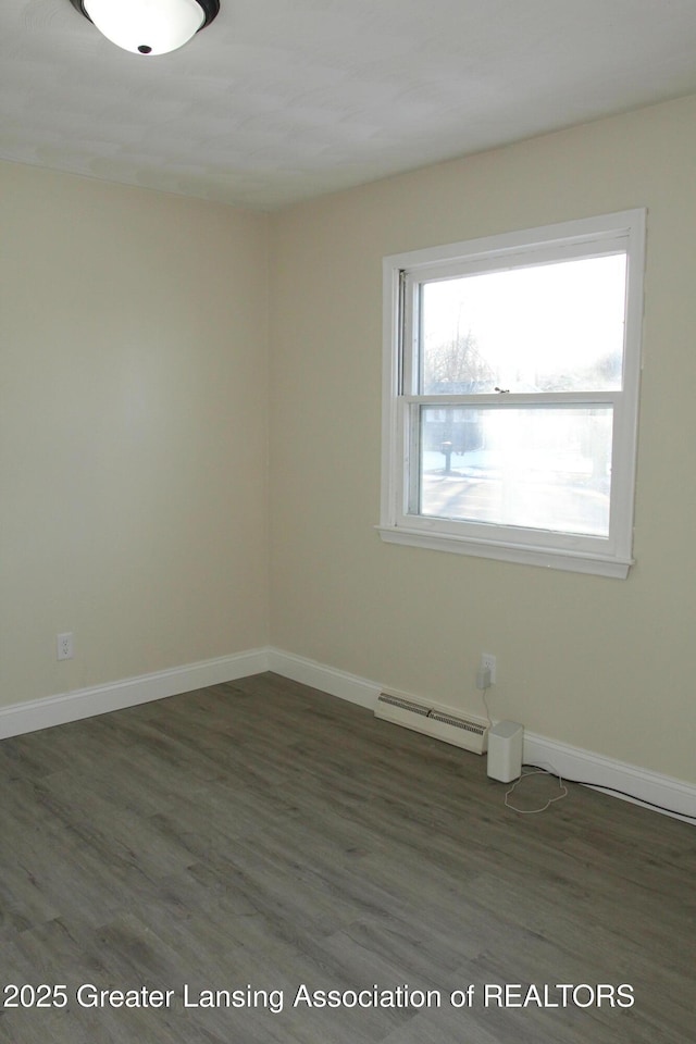 spare room featuring dark hardwood / wood-style floors and a baseboard heating unit