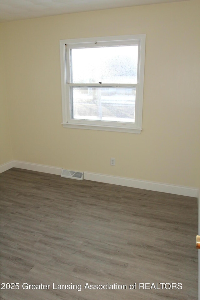 empty room with dark hardwood / wood-style flooring