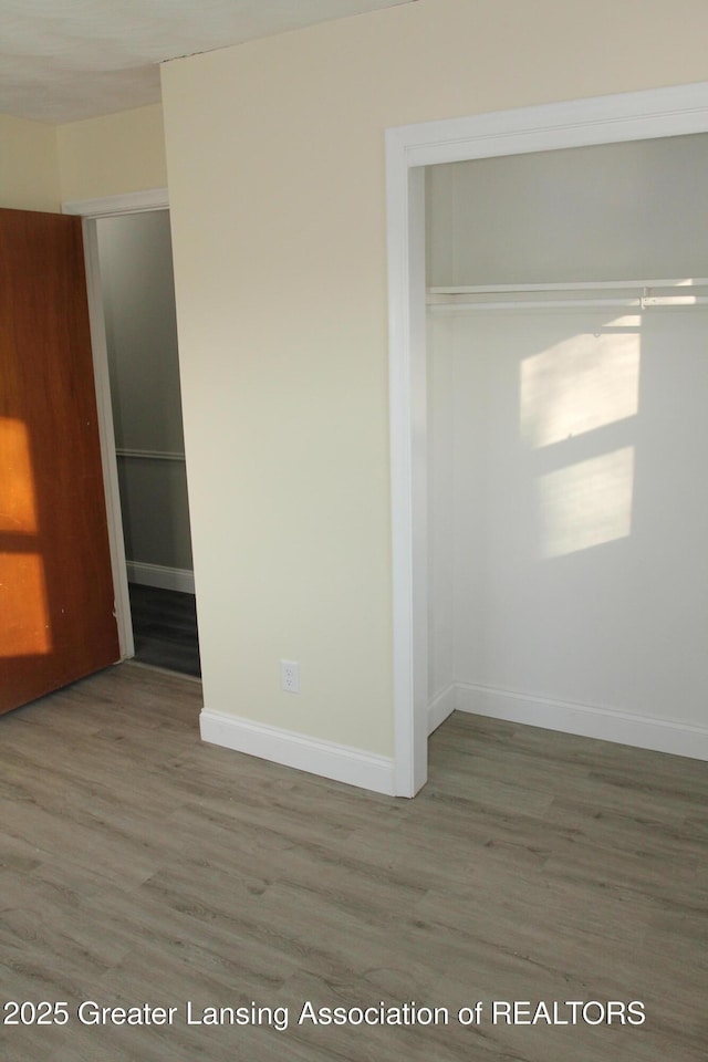 unfurnished bedroom with hardwood / wood-style floors and a closet