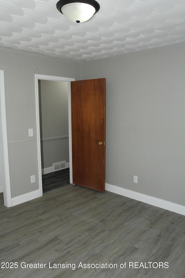 empty room featuring dark wood-type flooring