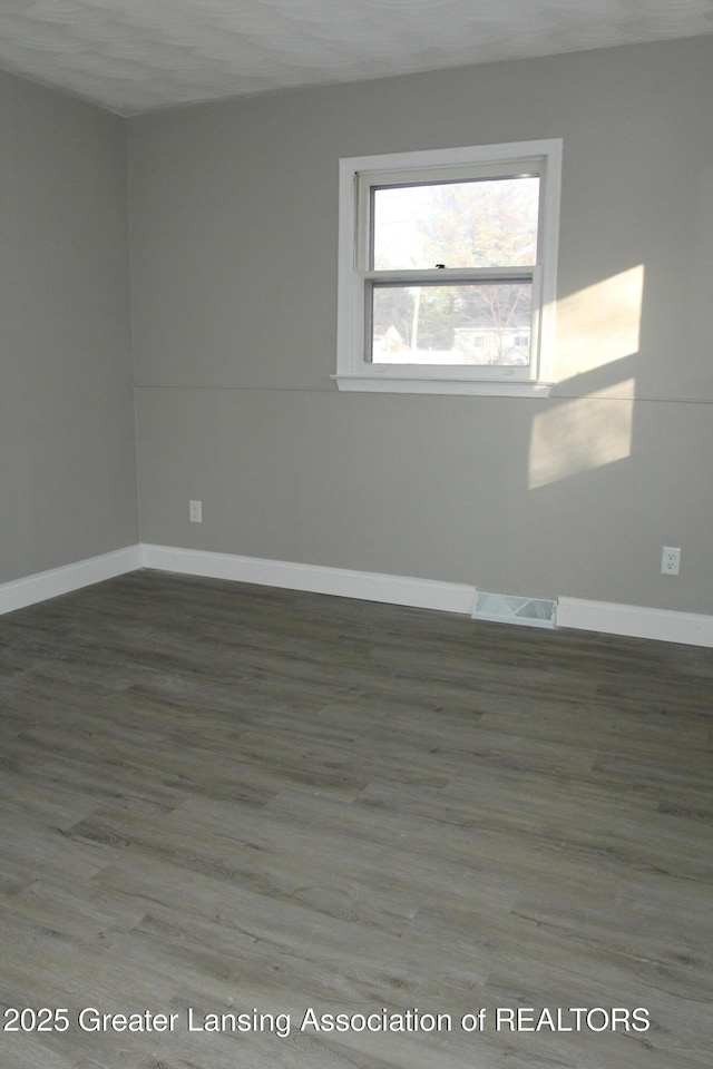 empty room with dark hardwood / wood-style floors