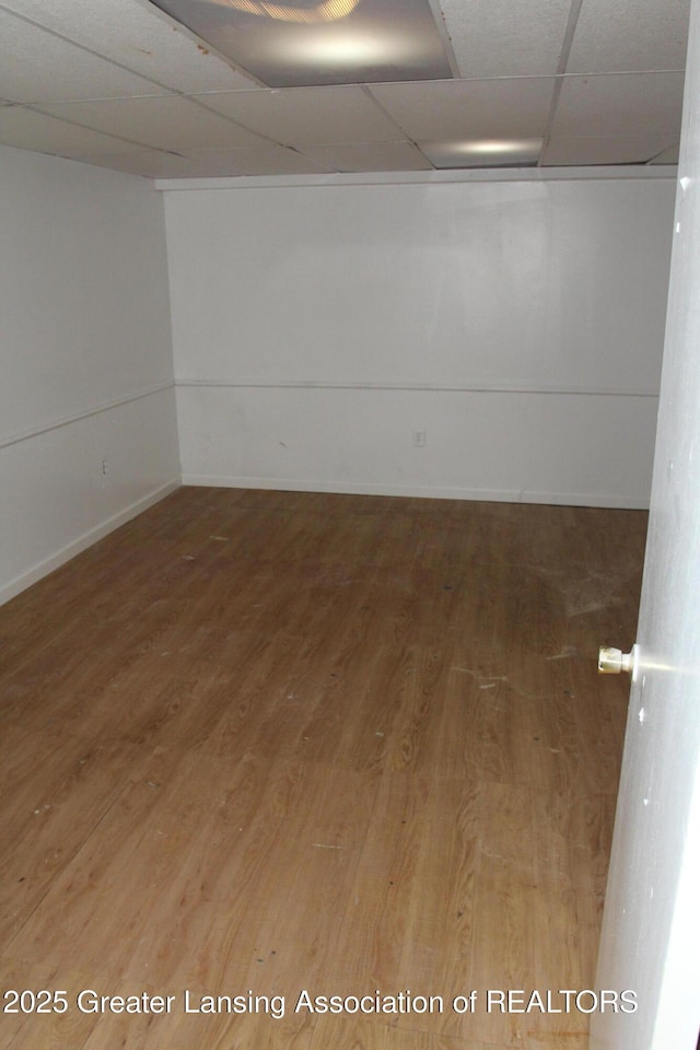 empty room featuring wood-type flooring and a paneled ceiling