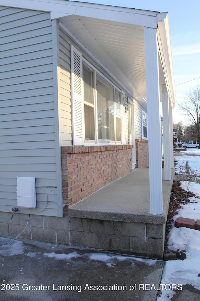 view of snowy exterior with covered porch