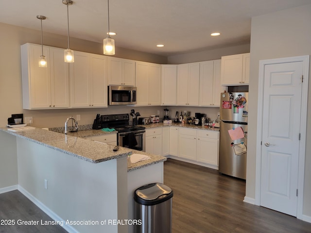 kitchen with appliances with stainless steel finishes, decorative light fixtures, white cabinets, and kitchen peninsula