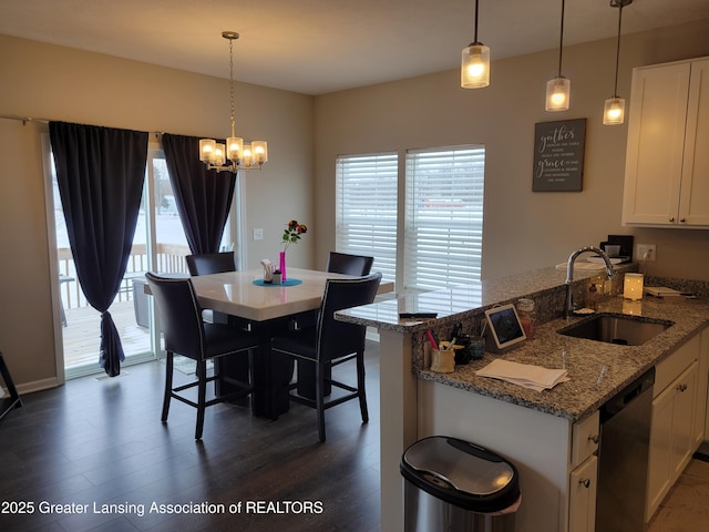 dining room with sink, a notable chandelier, and dark wood-type flooring