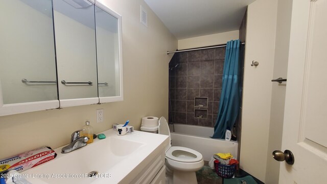 full bathroom featuring shower / tub combo with curtain, vanity, and toilet