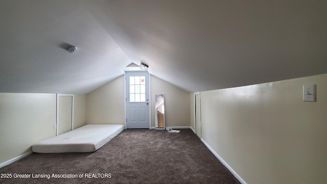 bonus room featuring lofted ceiling and dark carpet