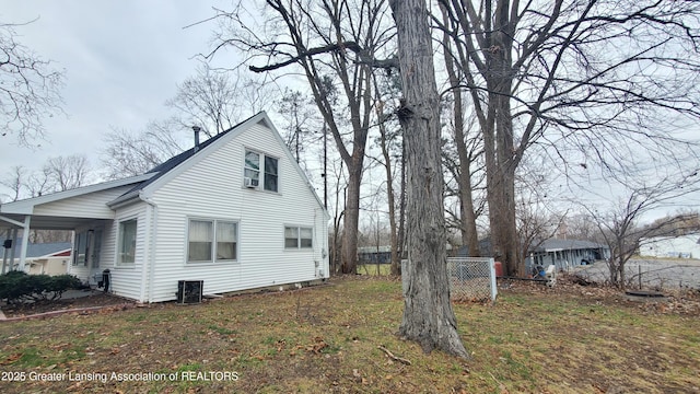 view of side of property featuring a yard and central AC unit