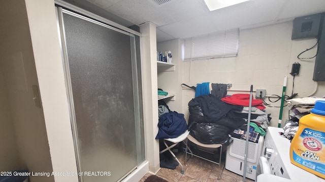 bathroom with a drop ceiling and a shower with door