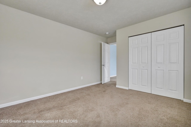 unfurnished bedroom with light carpet and a closet