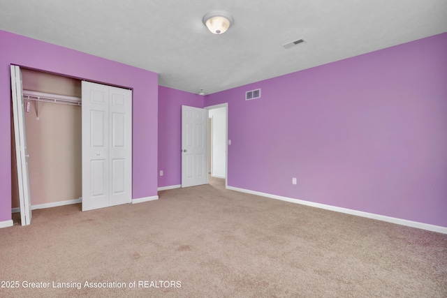 unfurnished bedroom with a closet and carpet flooring