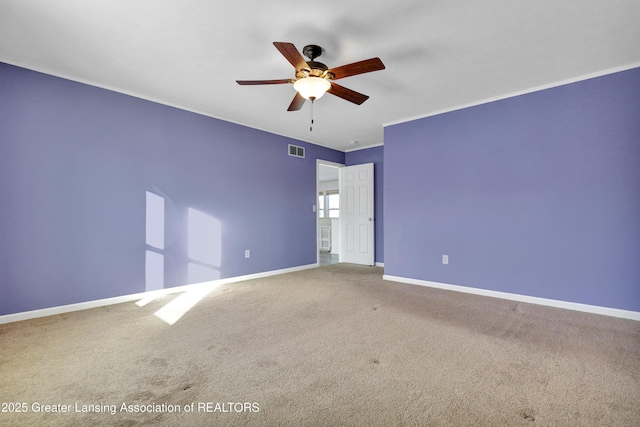 empty room with ceiling fan, ornamental molding, and carpet floors