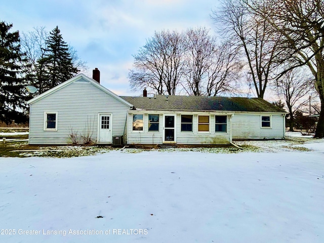 snow covered rear of property with cooling unit