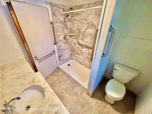 bathroom with sink, toilet, and tiled shower