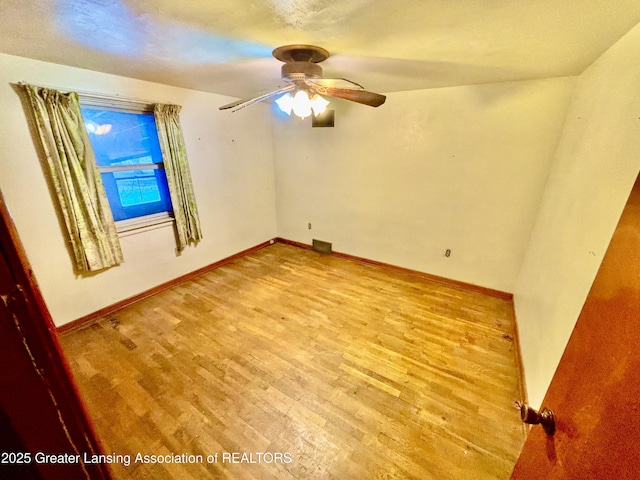 empty room with ceiling fan and light hardwood / wood-style flooring