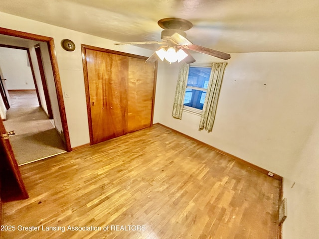 unfurnished bedroom featuring light hardwood / wood-style floors, a closet, and ceiling fan