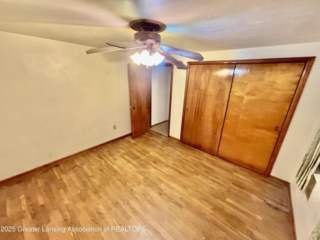 unfurnished bedroom featuring light hardwood / wood-style floors, a closet, and ceiling fan