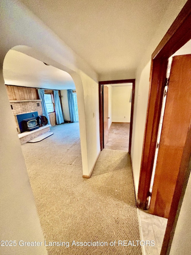 hallway with light carpet and a textured ceiling