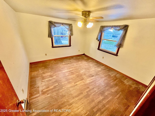 empty room featuring ceiling fan and hardwood / wood-style floors