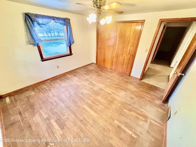 unfurnished bedroom with wood-type flooring, a closet, and ceiling fan