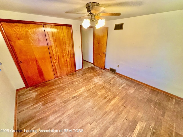 unfurnished bedroom featuring light hardwood / wood-style flooring, a closet, and ceiling fan