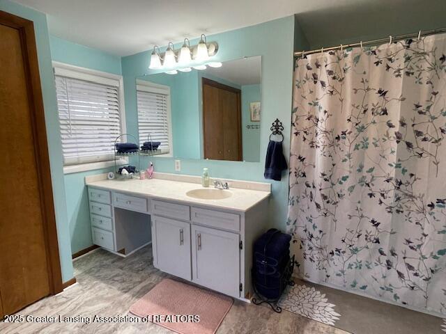 bathroom featuring curtained shower and vanity