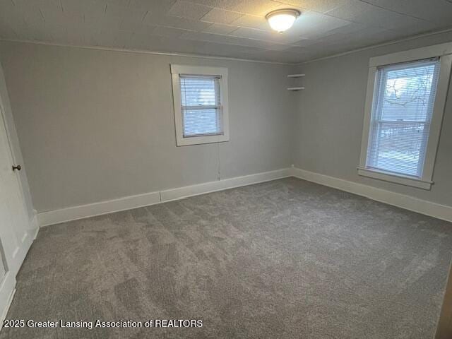 empty room featuring carpet flooring and baseboards