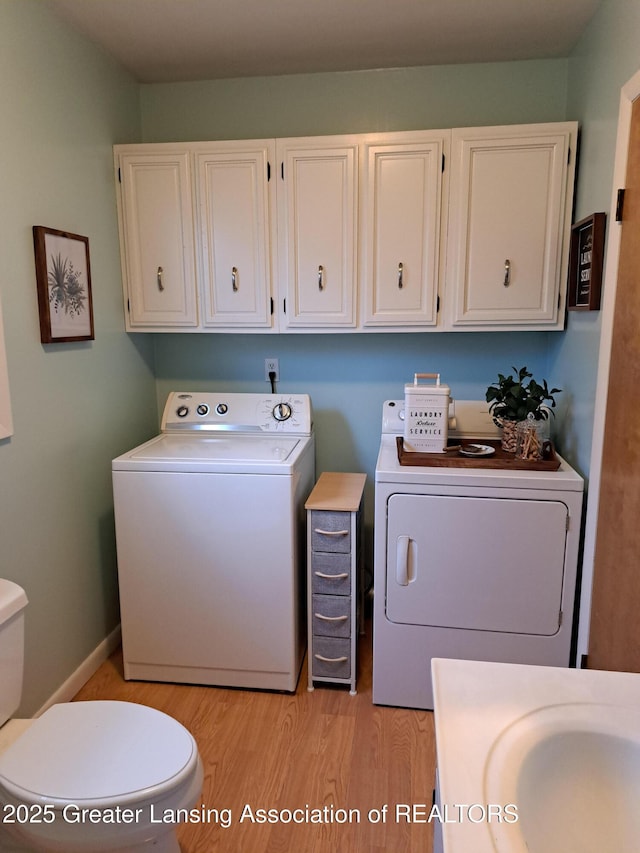 clothes washing area with laundry area, baseboards, light wood finished floors, and independent washer and dryer