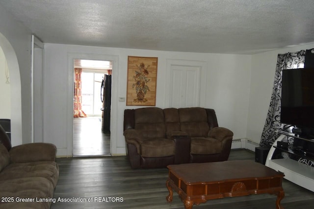 living room with dark wood-type flooring, a baseboard radiator, and a textured ceiling