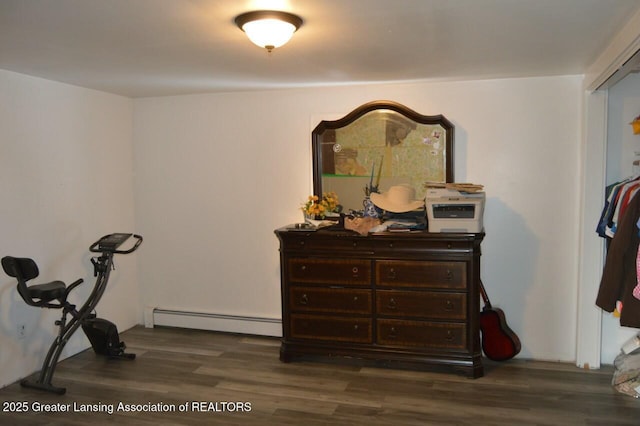 exercise room featuring baseboard heating and dark wood-type flooring