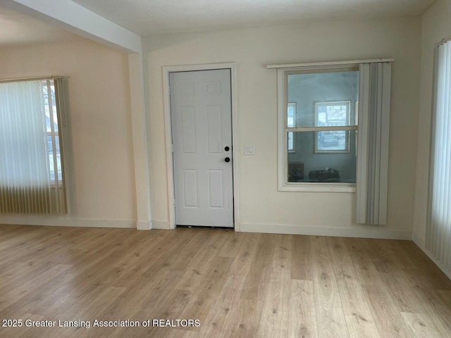 empty room with light hardwood / wood-style flooring and plenty of natural light