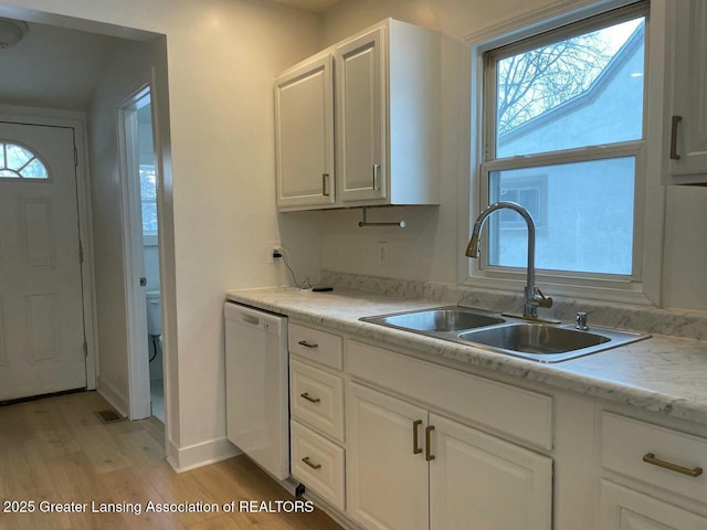 kitchen with white cabinetry, light hardwood / wood-style floors, dishwasher, and sink