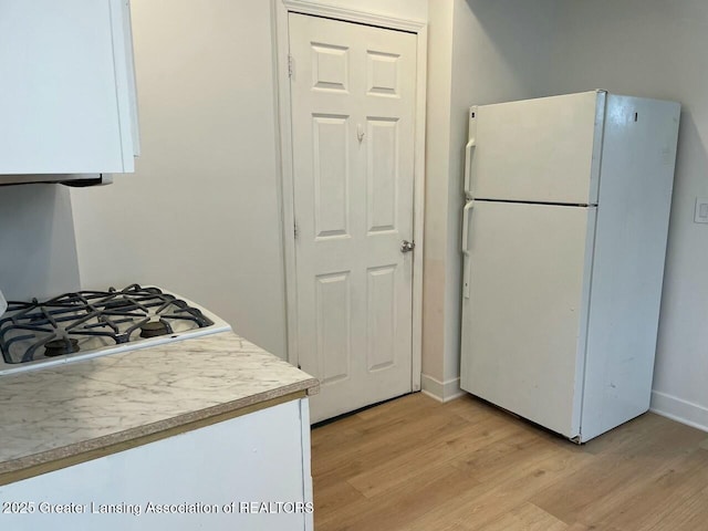 kitchen with light wood-type flooring and white fridge