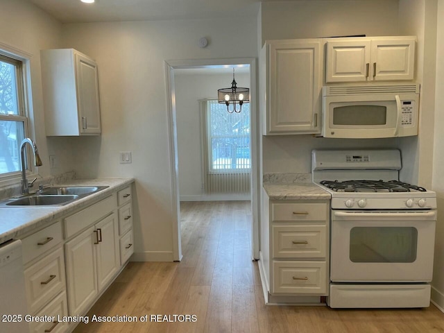 kitchen with white cabinetry, sink, light wood-type flooring, a notable chandelier, and white appliances