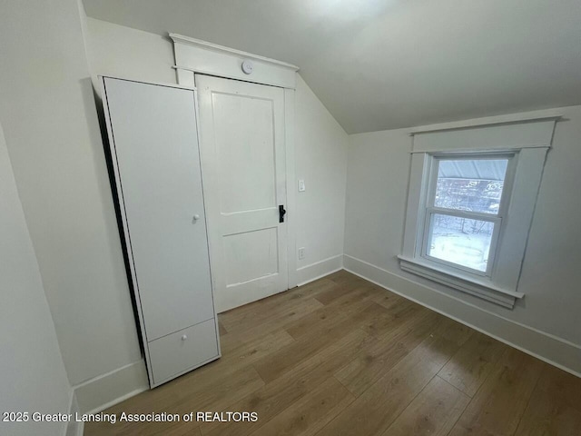 additional living space with vaulted ceiling and light hardwood / wood-style floors