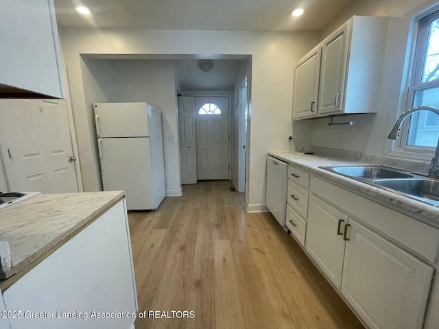 kitchen with sink, white cabinetry, white refrigerator, light hardwood / wood-style floors, and stainless steel dishwasher