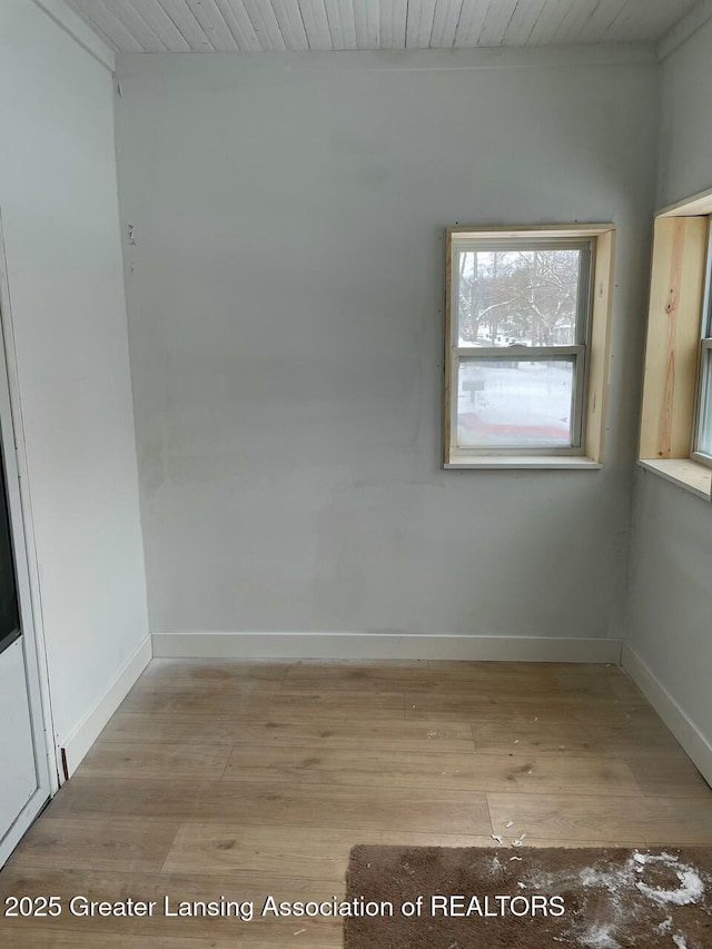 empty room with wooden ceiling and light hardwood / wood-style flooring