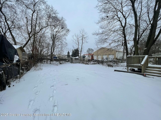 snowy yard featuring a wooden deck