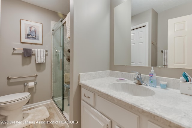 bathroom with vanity, a shower with shower door, and toilet