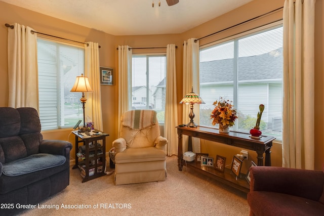 sitting room with ceiling fan, a healthy amount of sunlight, and carpet