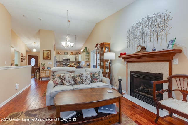 living room with hardwood / wood-style flooring, high vaulted ceiling, and an inviting chandelier