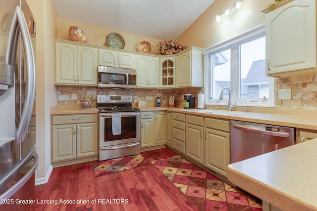 kitchen featuring appliances with stainless steel finishes, dark hardwood / wood-style floors, sink, and a textured ceiling