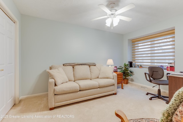 home office featuring light carpet and ceiling fan