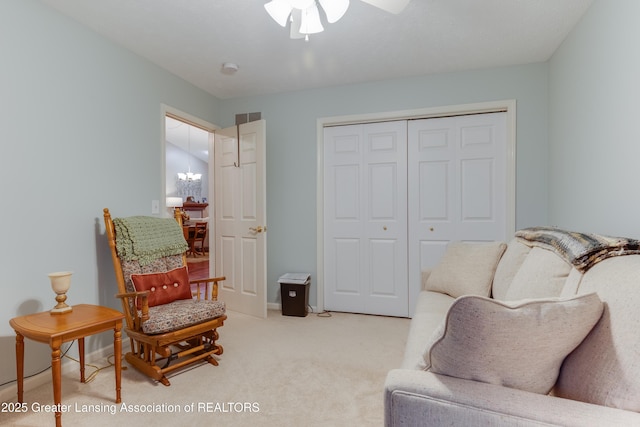 living area with ceiling fan with notable chandelier and light colored carpet