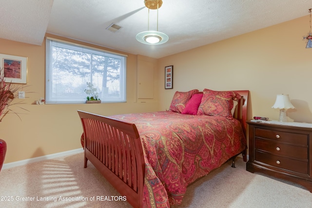 bedroom featuring light carpet and a textured ceiling