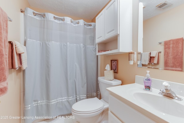 bathroom with vanity, a shower with curtain, toilet, and a textured ceiling