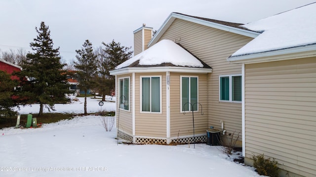 view of snow covered exterior featuring cooling unit